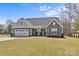 Charming one-story home featuring a stone and siding facade, a two-car garage, and a well-maintained lawn at 2017 Autumn Dr, Monroe, NC 28110