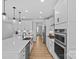 Modern kitchen with white cabinetry, stainless steel appliances, and a view into the hallway at 2017 Autumn Dr, Monroe, NC 28110