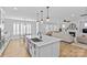 Bright kitchen with large island, pendant lighting, and an open view into the living room with fireplace at 2017 Autumn Dr, Monroe, NC 28110