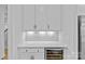 Elegant wet bar with white cabinets, marble backsplash, and a beverage cooler, perfect for entertaining guests at 2017 Autumn Dr, Monroe, NC 28110