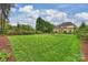 Expansive backyard featuring large lawn, pool, home, and privacy trees at 20635 Queensdale Dr, Cornelius, NC 28031