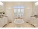The bathtub is centered between the dual vanities and a window with lots of natural light at 20635 Queensdale Dr, Cornelius, NC 28031