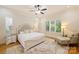 Serene bedroom with hardwood floors, large windows, plush bedding, and comfortable seating for relaxation at 20635 Queensdale Dr, Cornelius, NC 28031