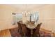 Elegant dining room with shuttered windows, a chandelier, and seating for six around a wooden table on an oriental rug at 20635 Queensdale Dr, Cornelius, NC 28031
