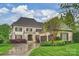 Charming two-story home featuring a stone facade, a two-car garage, and manicured landscaping under a cloudy blue sky at 20635 Queensdale Dr, Cornelius, NC 28031