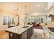 Spacious kitchen with granite counters, island, stainless appliances flowing into a living area with fireplace and ample natural light at 20635 Queensdale Dr, Cornelius, NC 28031