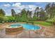 Beautiful in-ground pool with adjacent stone hot tub and lush landscaping at 20635 Queensdale Dr, Cornelius, NC 28031