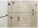 Tiled shower with frameless glass doors, rainfall shower head, and built-in shelving at 20635 Queensdale Dr, Cornelius, NC 28031