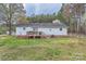 View of the home's backyard with a wooden deck and fenced yard at 209 Vanderbilt Ave, China Grove, NC 28023