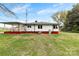 View of the back of a white home with red foundation and green lawn at 2300 Linwood Rd, Gastonia, NC 28052