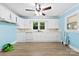 Inviting kitchen with blue walls, white cabinets, a ceiling fan, and modern appliances, offering a cheerful cooking space at 2300 Linwood Rd, Gastonia, NC 28052