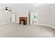 Bright living room featuring neutral walls, a vintage brick fireplace, and an inviting open doorway to the kitchen at 2300 Linwood Rd, Gastonia, NC 28052