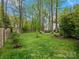 Expansive backyard view with a firepit seating area, storage shed, mature trees, and well-maintained lawn at 2812 Edgebrook Cir, Matthews, NC 28105
