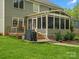 Green backyard with patio, grill, and view of the sunroom and house at 2812 Edgebrook Cir, Matthews, NC 28105