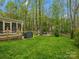 Green backyard with a grill, wood deck, outdoor seating area, and fire pit at 2812 Edgebrook Cir, Matthews, NC 28105