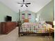 Spacious bedroom featuring light green walls, a ceiling fan, and a quaint four-poster bed at 2812 Edgebrook Cir, Matthews, NC 28105
