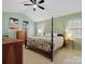 Bright bedroom with a four-poster bed, ceiling fan, and natural light from two windows at 2812 Edgebrook Cir, Matthews, NC 28105