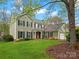Charming two-story home featuring a classic design, attached garage, lush lawn, and mature trees at 2812 Edgebrook Cir, Matthews, NC 28105
