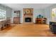 An open-concept living room with a brick fireplace, hardwood floors, and a cozy seating area at 2812 Edgebrook Cir, Matthews, NC 28105