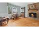 Comfortable living room with a brick fireplace, wooden desk, and large window overlooking the yard at 2812 Edgebrook Cir, Matthews, NC 28105