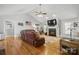 Cozy living room featuring hardwood floors, a fireplace, a ceiling fan, and comfortable leather seating at 2987 Irish St, Newton, NC 28658