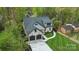 An aerial view showcases the new two-story home with a manicured lawn and mature trees at 3038 Northampton Dr, Charlotte, NC 28210