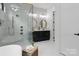 Bright bathroom featuring dual vanities, marble tiling, gold fixtures, and a glass-enclosed shower at 3038 Northampton Dr, Charlotte, NC 28210