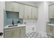 Laundry room featuring ample cabinet storage, tile backsplash, and black and white patterned floor at 3038 Northampton Dr, Charlotte, NC 28210
