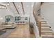 Open-concept living room and kitchen with wood beams, hardwood floors, and modern staircase at 3038 Northampton Dr, Charlotte, NC 28210