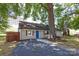 Charming home features a vibrant blue door, wood accents, and a mature tree shading the yard at 307 S Ransom St, Gastonia, NC 28052