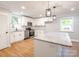 Well-lit kitchen with an island, white cabinets, stainless steel appliances, and modern pendant lights at 307 S Ransom St, Gastonia, NC 28052