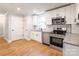 Modern kitchen featuring white cabinets, stainless steel appliances, and granite countertops at 307 S Ransom St, Gastonia, NC 28052