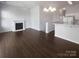 Open-concept living room featuring hardwood floors, a fireplace, and a pass-through to the adjacent kitchen at 3489 Chagall Ct, Charlotte, NC 28205