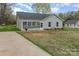 Home with a sunroom, and long driveway, complemented by a well-maintained lawn at 413 E Henderson Es St, East Spencer, NC 28144