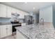 Granite countertop with stainless steel appliances offers modern updates in the kitchen at 413 E Henderson Es St, East Spencer, NC 28144