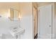 Well-lit bathroom with a classic pedestal sink, vanity mirror, and a shower with curtain at 431 Sullivan Rd, Statesville, NC 28677