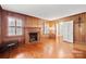 Elegant living room featuring wood paneling, hardwood floors, and a brick fireplace, perfect for relaxing or entertaining at 431 Sullivan Rd, Statesville, NC 28677