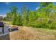 View of the backyard featuring a fire pit, mature trees, and a fence at 4503 Hunton Dale Nw Rd, Concord, NC 28027