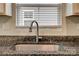 Close up of a stainless steel sink, faucet, and granite countertop in a bright kitchen at 4503 Hunton Dale Nw Rd, Concord, NC 28027
