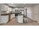 Modern kitchen features white cabinetry, stainless steel appliances, and a functional island with barstool seating at 4503 Hunton Dale Nw Rd, Concord, NC 28027