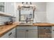 Well-lit kitchen featuring butcher block countertops, white subway tile backsplash, and stainless steel dishwasher at 511 Plymouth Ave, Salisbury, NC 28144