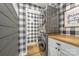 The laundry room features a stacked washer and dryer, butcher block countertop and modern buffalo check wallpaper at 511 Plymouth Ave, Salisbury, NC 28144