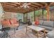 Inviting screened-in porch with ceiling fan, wicker furniture, outdoor rug, and wooded backyard views at 511 Plymouth Ave, Salisbury, NC 28144