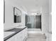 Modern bathroom featuring double vanity, glass shower, and gray tiled walls at 603 Mt. Wesley Church Rd, Hiddenite, NC 28636