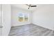 A bright bedroom with two windows, gray wood-look floors, and a ceiling fan at 603 Mt. Wesley Church Rd, Hiddenite, NC 28636