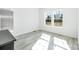 Sunlit bedroom with gray wood-look floors and white walls with large windows overlooking the front yard at 603 Mt. Wesley Church Rd, Hiddenite, NC 28636