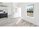 Bright entryway with gray wood-look flooring, an open front door, and view into the open kitchen area at 603 Mt. Wesley Church Rd, Hiddenite, NC 28636