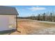 Side view of a white home with a quaint porch, set against a backdrop of natural scenery and an open sky at 603 Mt. Wesley Church Rd, Hiddenite, NC 28636