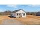 Charming white cottage-style home with a covered front porch and a well-maintained yard in a rural setting at 603 Mt. Wesley Church Rd, Hiddenite, NC 28636