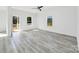 Bright, airy living room with modern gray wood-look flooring, ceiling fan, white walls and trim, and access to the exterior at 603 Mt. Wesley Church Rd, Hiddenite, NC 28636